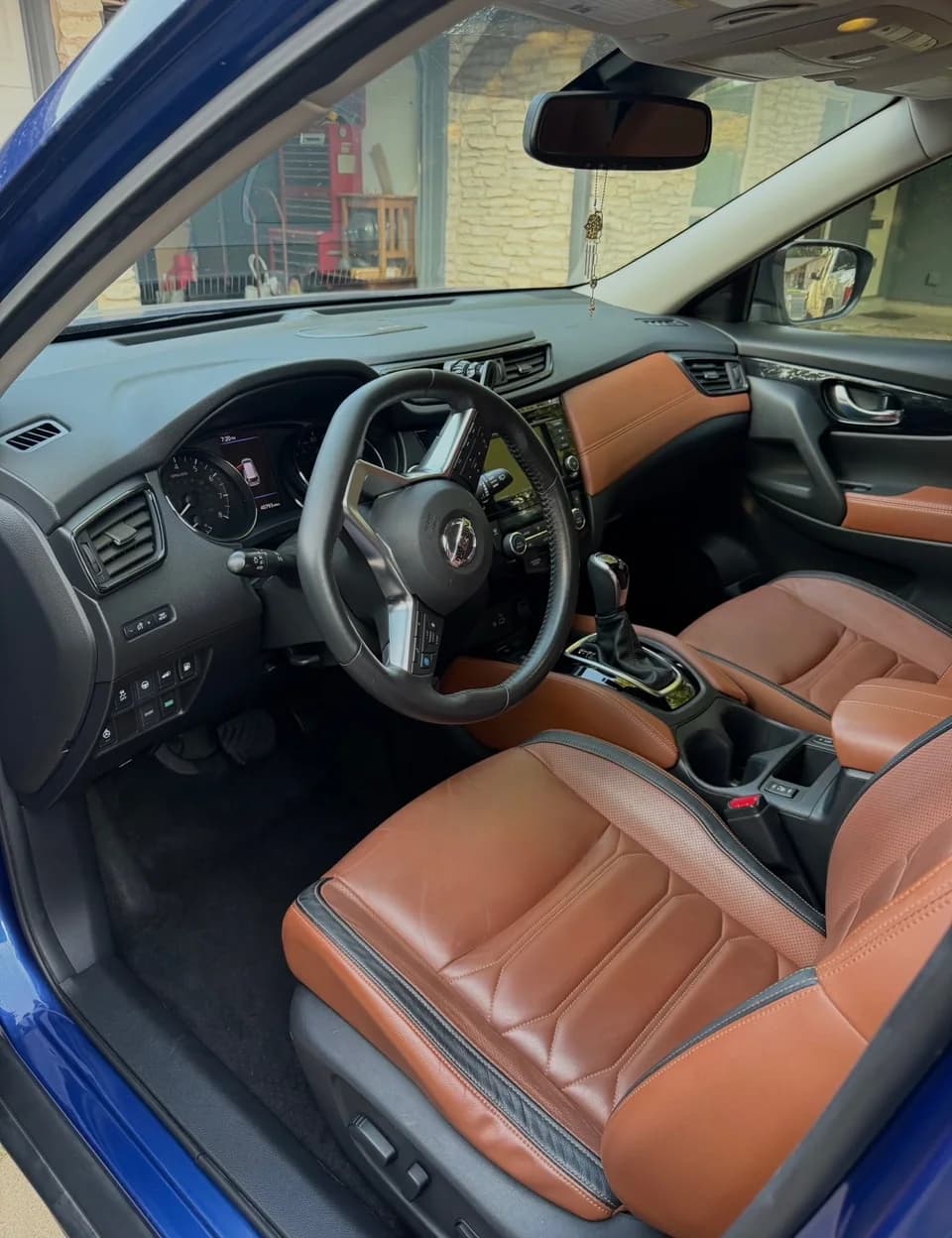 Nissan cabin with tan leather front seats and black dashboard