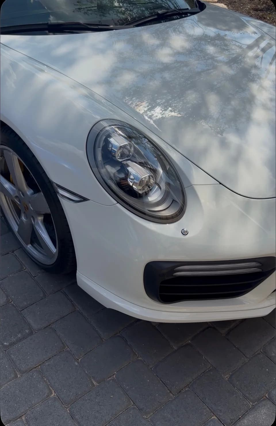 White Porsche hood, headlight and front wheel