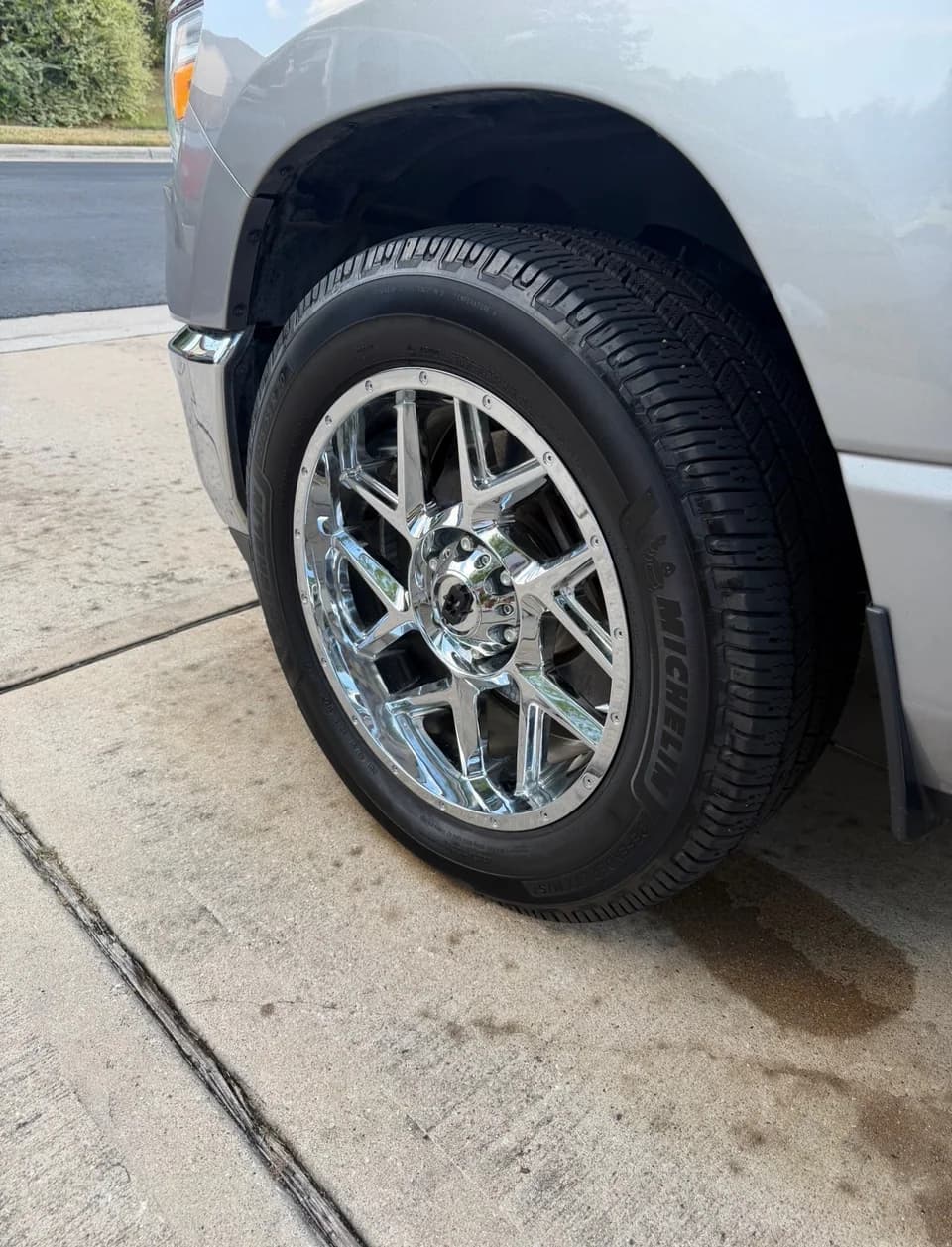 Chrome wheel and tire on a silver pickup truck